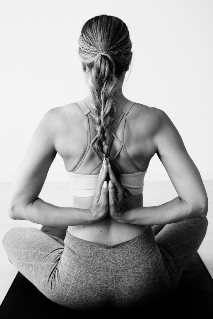 Yoga 3 woman sitting lotus position with her hands anjali mudra her back